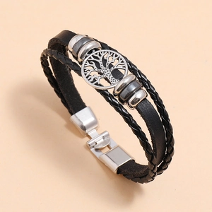 Detailed view of multi-layered leather bracelet featuring tree of life charm and metal beads