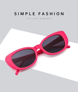 Detail view of stylish magenta cat-eye sunglasses with thick vintage frames and retro design