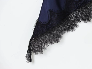 Detailed close-up of dark blue satin fabric with exquisite black eyelash lace trim
