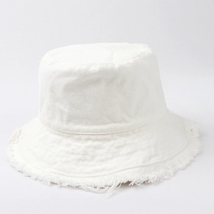 Close-up of white canvas bucket hat featuring vintage frayed edges and fringe detail