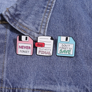 Detailed view of nostalgic floppy disk and document enamel pins on a denim jacket