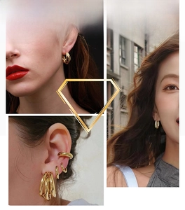 Close-up of geometric gold hoop earrings and ear cuffs on a model for a modern look