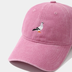 Dettaglio del ricamo a piccione su cappello da baseball rosa in cotone lavato regolabile