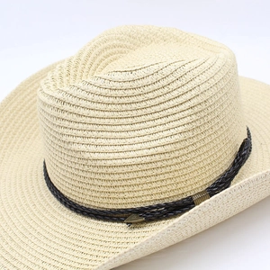 Macro shot of fine woven texture and retro bronze arrow detail on a beige cowboy sun hat
