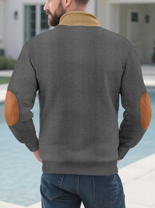 Detail of men's knit sweater featuring khaki collar and brown elbow patches on grey fabric