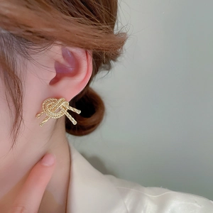 Chic knotted gold-tone metal stud earrings for women with unique woven texture design