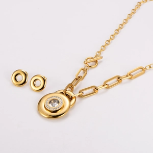 Macro view of gold-plated paperclip necklace and matching stud earrings with zircon