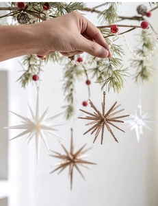 Detailed view of champagne and white glitter star ornaments hanging on a Christmas tree