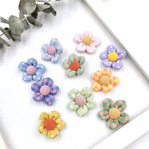 Flat lay of colorful fabric flower accessories with checkered patterns and velvet centers