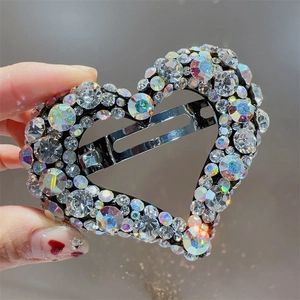 Gros plan détail d'une pince à cheveux cœur en strass scintillants, barrette cristal.
