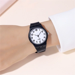 Macro view of minimalist quartz watch with black silicone strap and white numeric dial
