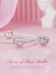 Detailed view of S925 style silver charm bracelet with pink heart and swan pendants