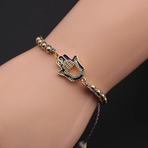 Detail of Hamsa Hand charm with blue enamel and zircon on a colorful braided bracelet