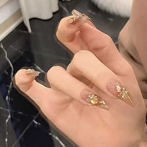 Detail of handmade long coffin nails with gold foil and 3D metal cross charms