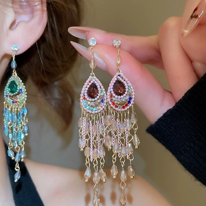 Macro shot of vintage style earrings with red teardrop stone and crystal tassels