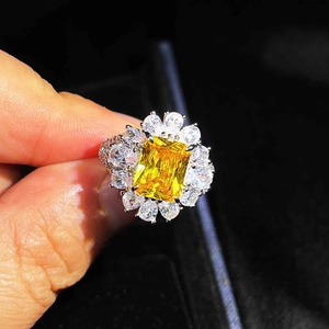 Macro shot of a luxury silver ring featuring a large emerald-cut yellow gemstone centerpiece