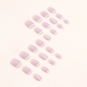 Short white French press-on nails with pink glitter gradient and white leaf patterns