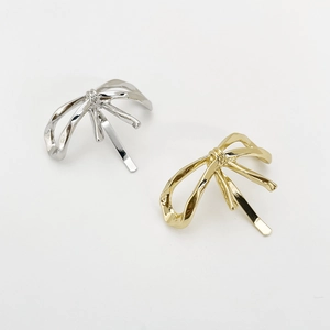 Detailed view of elegant gold and silver bow hair clips with a polished metallic finish
