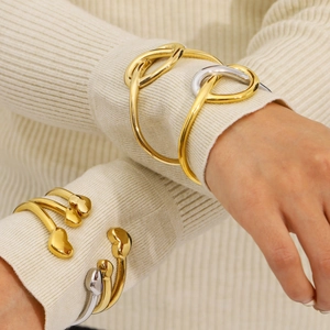 Minimalist gold and silver stainless steel heart knot bracelet set worn on wrist