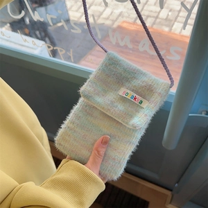 Detail of plush crossbody phone bag showing colorful fuzzy texture and purple strap