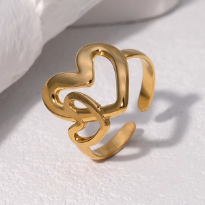 Modern 18K gold-plated double heart open ring displayed on a white textured stone pedestal