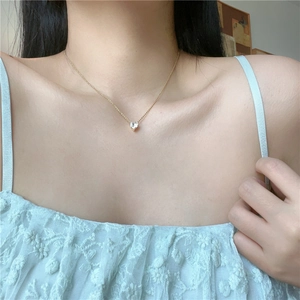 Minimalist heart-shaped zircon gold necklace for women on a model neck with lace shirt