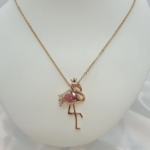 Close-up of rose gold flamingo necklace pendant with crown and pink waterdrop zircon