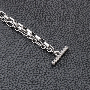 Gros plan détaillé d'un bracelet en acier inoxydable argenté avec fermoir OT et doubles chaînes