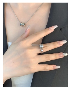 Detail of S925 sterling silver pearl ring and Forever engraved necklace on model