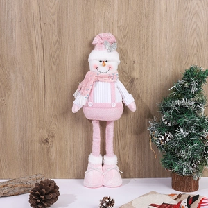 Detail of pink Christmas snowman plush with long legs and sequin scarf on wooden background
