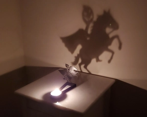 Dramatic shadow projection of a pumpkin knight on Pegasus metal candle holder decor