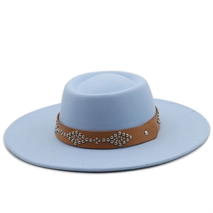 Detail of light blue wool fedora hat with wide brim, brown leather strap, and metal rivets