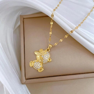 Detail of a luxurious gold plated boy pendant necklace with sparkling rhinestones on silk