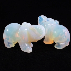Macro shot of two opal elephant figurines showing vibrant orange and pink fire effects