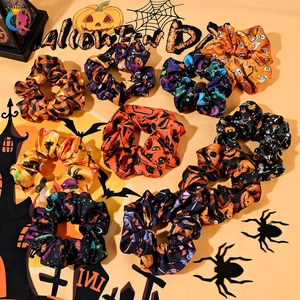 Flat lay of 9 Halloween hair scrunchies with pumpkin ghost and bat patterns on orange background
