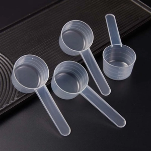 Set of four transparent plastic measuring spoons with handles and ml scale markings