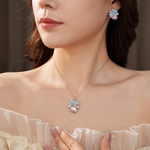 Détails d'un élégant ensemble de bijoux avec fleurs bleues et gouttes de cristal rose