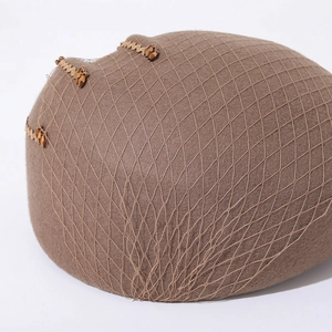 Detail of brown wool felt beret featuring fine mesh veil and elegant beaded ornaments