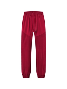 Detailed view of burgundy jogger pants with drawstring waist and elastic cuffs