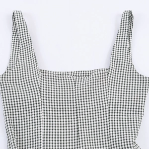 Detailed view of the square neckline and green plaid pattern on this sleeveless dress