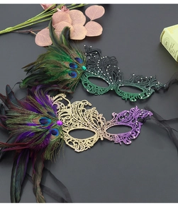 Close-up of lace masquerade mask with peacock feathers and glittering rhinestone details