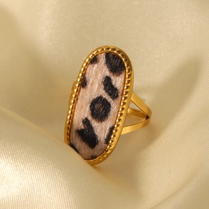 Macro view of gold stainless steel ring with oval leopard print velvet inlay on satin