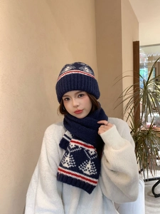 Dettaglio di set berretto e sciarpa in maglia Fair Isle blu navy con motivi rossi