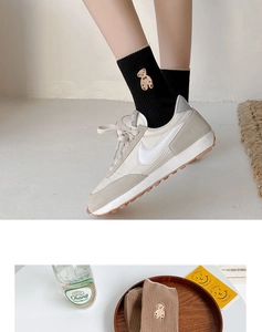 Détail rapproché des chaussettes avec broderie ours et texture en maille côtelée