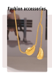 Detail of 18k gold plated teardrop pendants with hammered texture on a sleek snake chain
