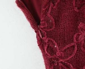 Macro detail of burgundy mesh dress with flocking sequins and hidden zipper closure