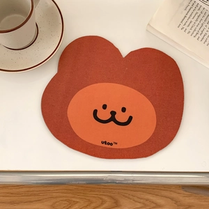 Close-up of cute bear-shaped mouse pad on a desk with coffee cup and books