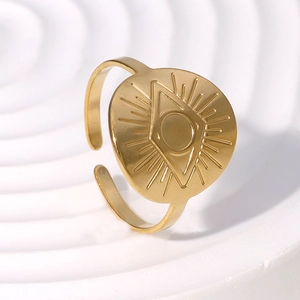 Golden Evil Eye open ring in polished stainless steel on a white textured stand