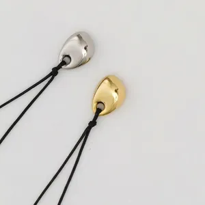 Minimalist gold and silver pebble pendants on black cord necklaces for men and women