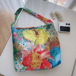 Detailed view of colorful floral tote bag fabric with simple wish woven brand label